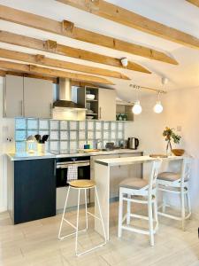 a kitchen with wooden ceilings and a kitchen island with stools at Modern self contained tiny home with patio in Loughton