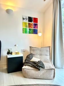 a bedroom with a bed with a blanket and a table at Modern self contained tiny home with patio in Loughton