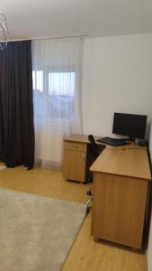 an office with a desk with a computer and a window at Emi's House in Sângeorgiu de Mureș