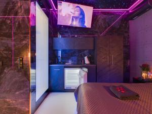 a room with a bed and a kitchen with purple lights at LoveAparts Marki Romantic Stay in Marki