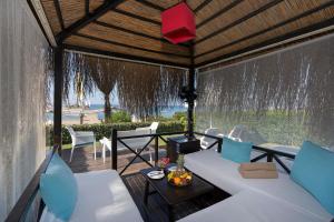 a porch with a white couch and a table at Limak Atlantis Deluxe Hotel Belek in Belek