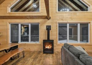 a living room with a fireplace in a log cabin at Spa Pool Table Ultimate Comfort - OSE Le Refuge in Saint Come