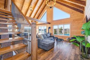 a living room with a staircase and a couch at Spa Pool Table Ultimate Comfort - OSE Le Refuge in Saint Come