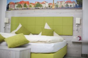 a bedroom with a bed with green and white pillows at Adler Golf-& Tagungshotel in Harth - Pöllnitz +56 photos