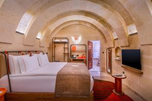 ein Schlafzimmer mit einem Bett und einem Fernseher in einem Zimmer in der Unterkunft Das 1350 in Uchisar