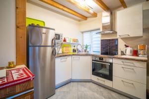 a kitchen with a stainless steel refrigerator and white cabinets at Au nid d'Alsace - SPA et sauna privé in Orschwiller