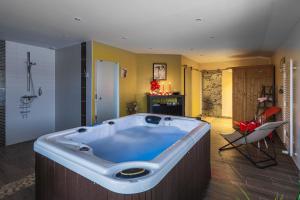 a large tub in a bathroom with a chair at Ome sweet home in Laubressel