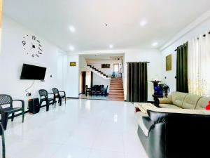 a living room with a couch and a tv at Lotus villa in Matara