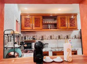 a kitchen with wooden cabinets and a counter top at Résidence imeris mbour 8 chambres in Dinnguiraye