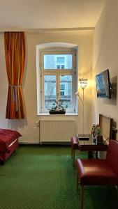 a living room with a window and a green carpet at Pension Stadthalle in Vienna