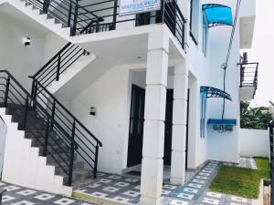 a white building with stairs and a door at Marissa Villa in Katunayaka