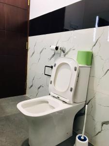 a bathroom with a toilet with a toilet brush at Marissa Villa in Katunayaka +14 photos