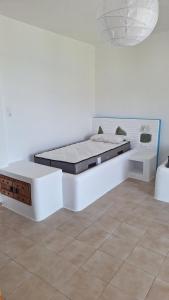 a white room with a bed in the corner at Chryssa Bungalows in Andros