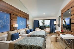 a hotel room with two beds and a living room at Limak Atlantis Deluxe Hotel Belek in Belek