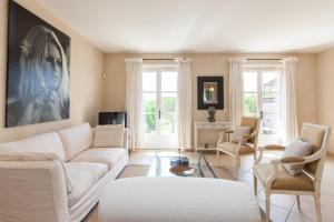a living room with a white couch and chairs at Saint-Tropez Golf Residences in Saint-Tropez