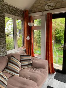 a living room with a couch and two windows at Selfcatering Apartment in Currahy Bridge