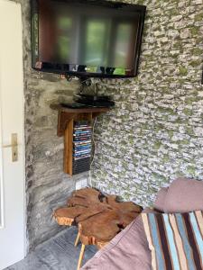 a living room with a flat screen tv on a stone wall at Selfcatering Apartment in Currahy Bridge