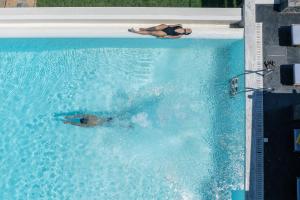 a person swimming in a swimming pool at Villa Dei Sogni, for the Design Lovers,By ThinkVilla in Agia Pelagia
