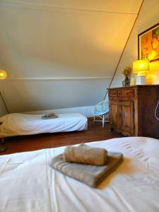a bedroom with two beds and a dresser with a towel at Camembert & Crustacés in Veulettes-sur-Mer