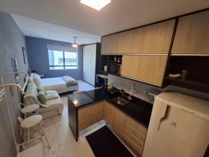 a small room with a kitchen and a bedroom at Conjunto Estúdio e Duplex Selenita by Rhouses in Barueri