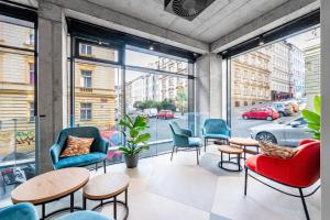 a room with chairs and tables and windows at Jasminn Apartments in Prague