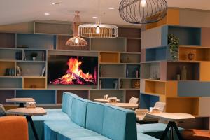 a living room with a fireplace and blue furniture at Hampton By Hilton Ordu in Ordu