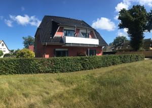 a red house with a window and a hedge at Sommerwiese in Prerow