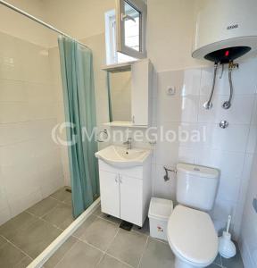 a bathroom with a toilet and a sink at Apartmans White perl in Sutomore +11 photos