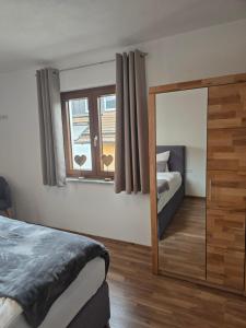 a bedroom with a mirror and a bed and a window at Ferienwohnung Wilde Hilde inklusive aktivCARD in Arrach