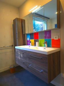 a bathroom with a sink and a colorful tile wall at Camembert & Crustacés in Veulettes-sur-Mer +51 photos