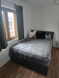 a bedroom with a bed with a teddy bear on it at Ferienwohnung Wilde Hilde inklusive aktivCARD in Arrach