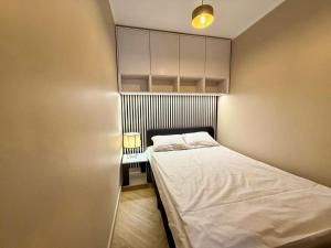 a small bedroom with a bed and a cabinet at Fly Apartment Modlin by JumpInHere in Nowy Dwór Mazowiecki