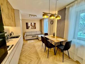 a kitchen and living room with a table and chairs at Fly Apartment Modlin by JumpInHere in Nowy Dwór Mazowiecki +3 photos