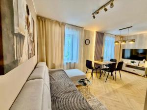 a living room with a couch and a table at Fly Apartment Modlin by JumpInHere in Nowy Dwór Mazowiecki