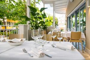 a table with glasses and napkins on a white table cloth at Hotel Regal in Rimini +34 photos