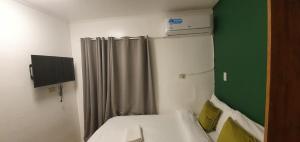 a small room with a bed and a shower at AJ Tourist Inn in Coron