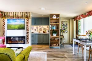 a living room with a fireplace and a kitchen at Harts Leap in Redmarley DʼAbitot