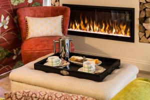 a tray of food on a chair with a fireplace at Harts Leap in Redmarley DʼAbitot +21 photos
