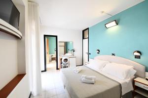 a hotel room with a bed with two towels on it at Hotel Criniera D'oro in Rimini