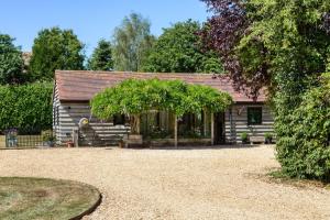 a log cabin with a tree in front of it at Harts Leap in Redmarley DʼAbitot