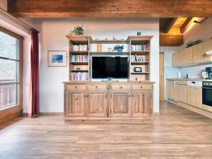 a living room with a television on a wooden cabinet at Sonnenhof Seeg 14 in Seeg