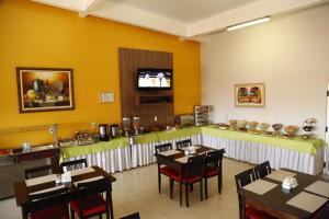 a restaurant with tables and a bar with a tv at Porto Center Hotel in Luís Eduardo Magalhães