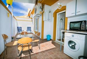 a kitchen and dining room with a table and a washing machine at Bluemoon in Mazarrón