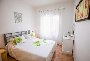 a bedroom with a bed with white sheets and a window at Bluemoon in Mazarrón