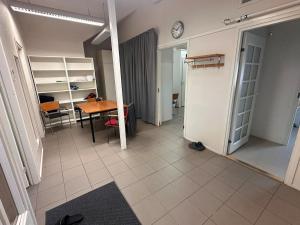 an empty room with a table and a clock on the wall at Affordable, fully equipped practical housing! in Laivaniemi +5 photos