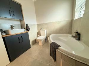 a bathroom with a tub and a sink and a toilet at Die Stal in Wellington +33 photos