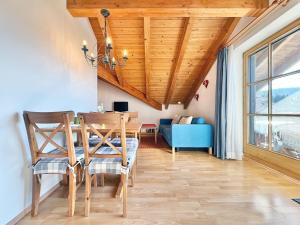 a dining room with a wooden ceiling and a table and chairs at Sonnenhof Seeg 17 in Seeg