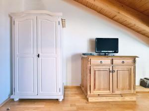a room with a door and a tv on a cabinet at Sonnenhof Seeg 17 in Seeg