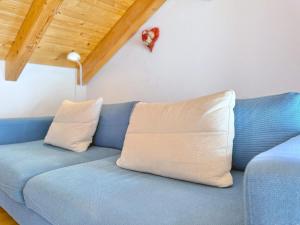 a blue couch with two pillows in a room at Sonnenhof Seeg 17 in Seeg