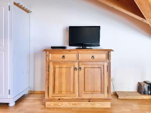 a tv on top of a wooden cabinet in a room at Sonnenhof Seeg 17 in Seeg